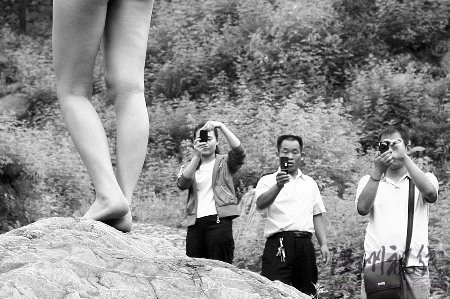 村民持樹枝驅趕拍寫真裸女 稱丟人現眼(組圖)