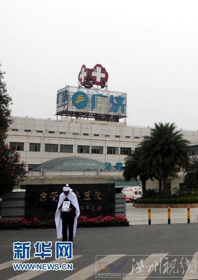 4月6日,在東莞市鳳崗鎮廣濟醫院大門前,肖海國站在醫院門口討公道。 新華社記者 周強 攝