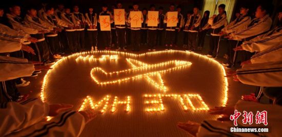 浙江諸暨海亮國際學校師生點燃蠟燭為馬航失聯飛機上的乘客祈福