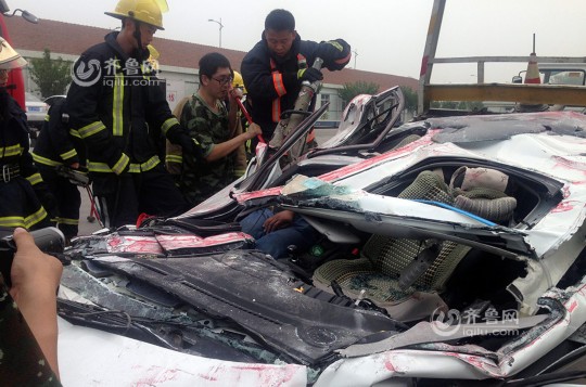 青島轎車被集裝箱壓扁車內(nèi)兩人奇跡生還