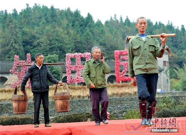 大媽們肩挑、手提農(nóng)具走T臺